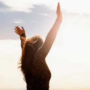 Woman lifting arms in praise to God
