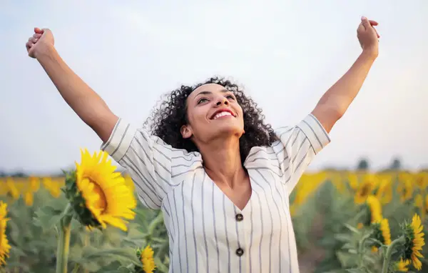 Woman standing in a field and praising God