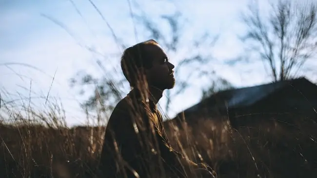 Man praying, meditating in a field