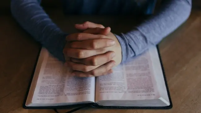 Man praying with open Bible