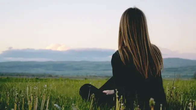 Woman praying, meditating in a field